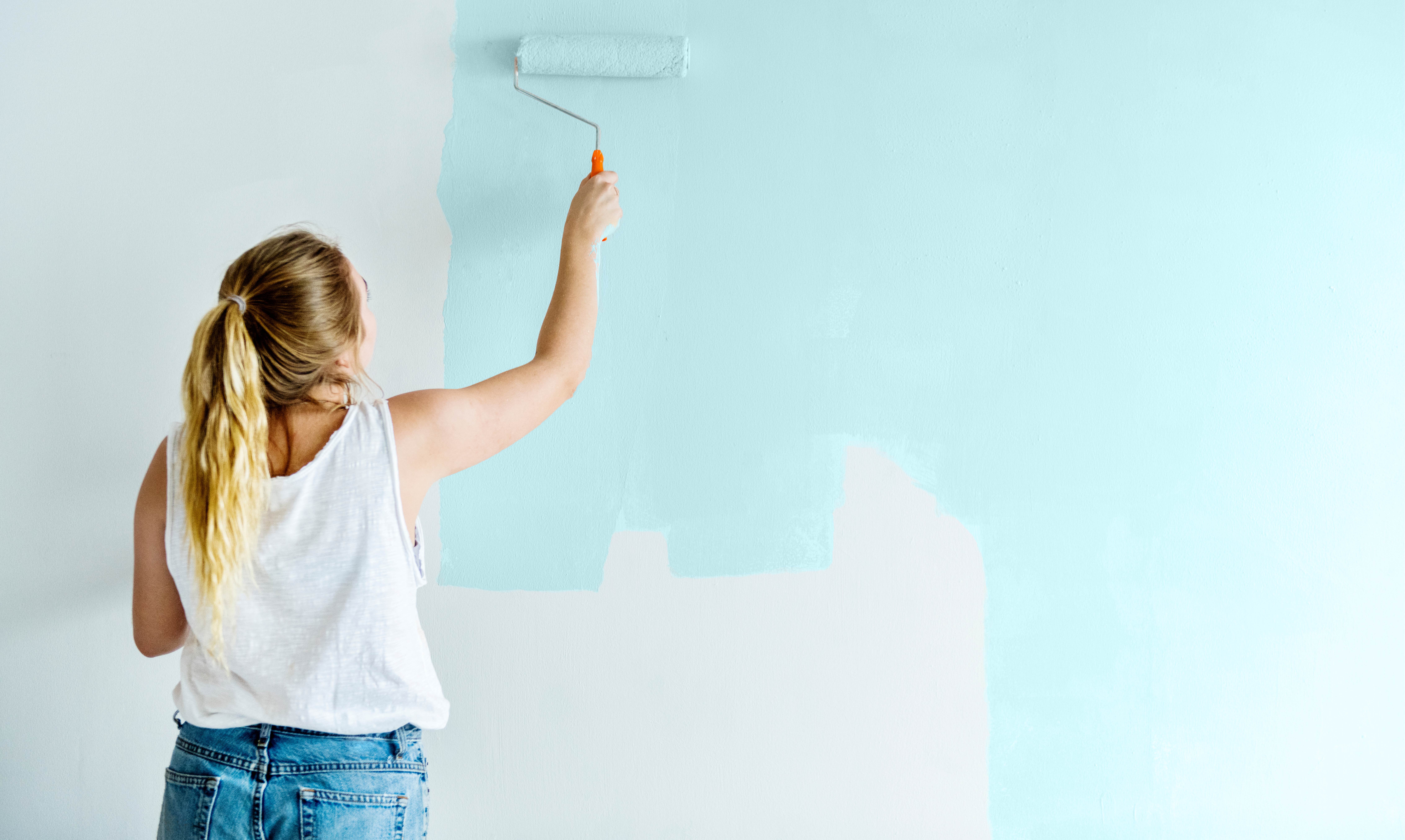 woman painting blue wall