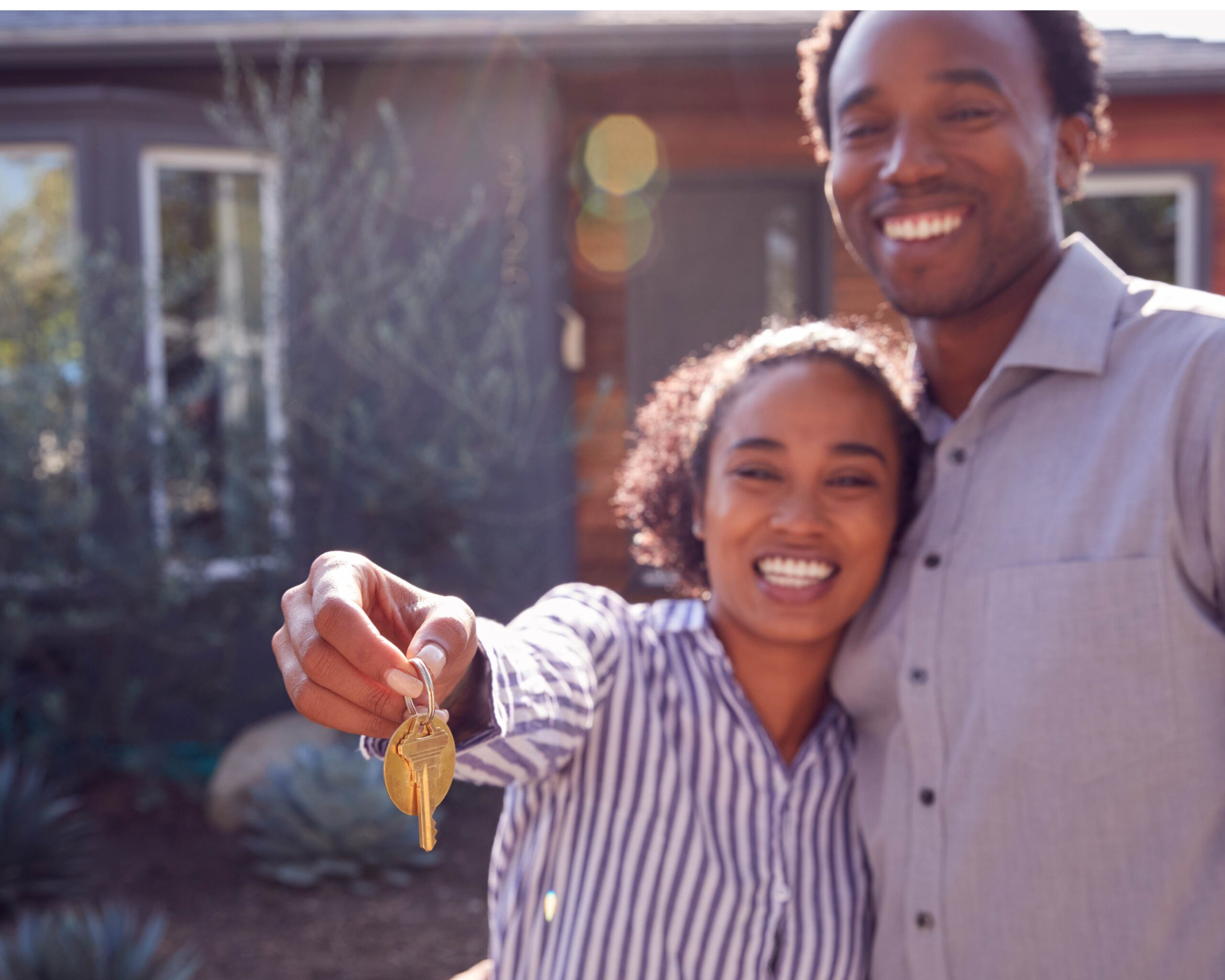 happy couple with keys to house unfocused