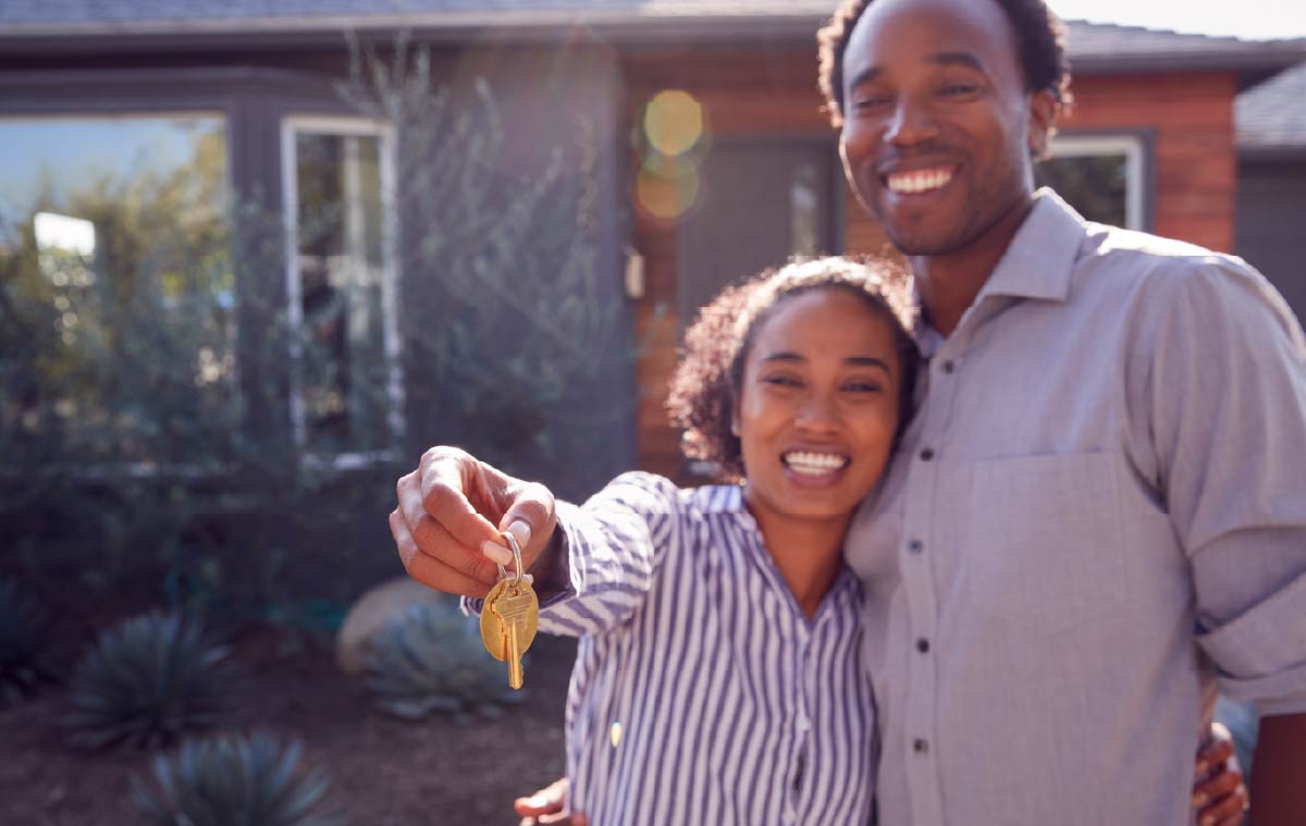 happy couple with keys to house unfocused
